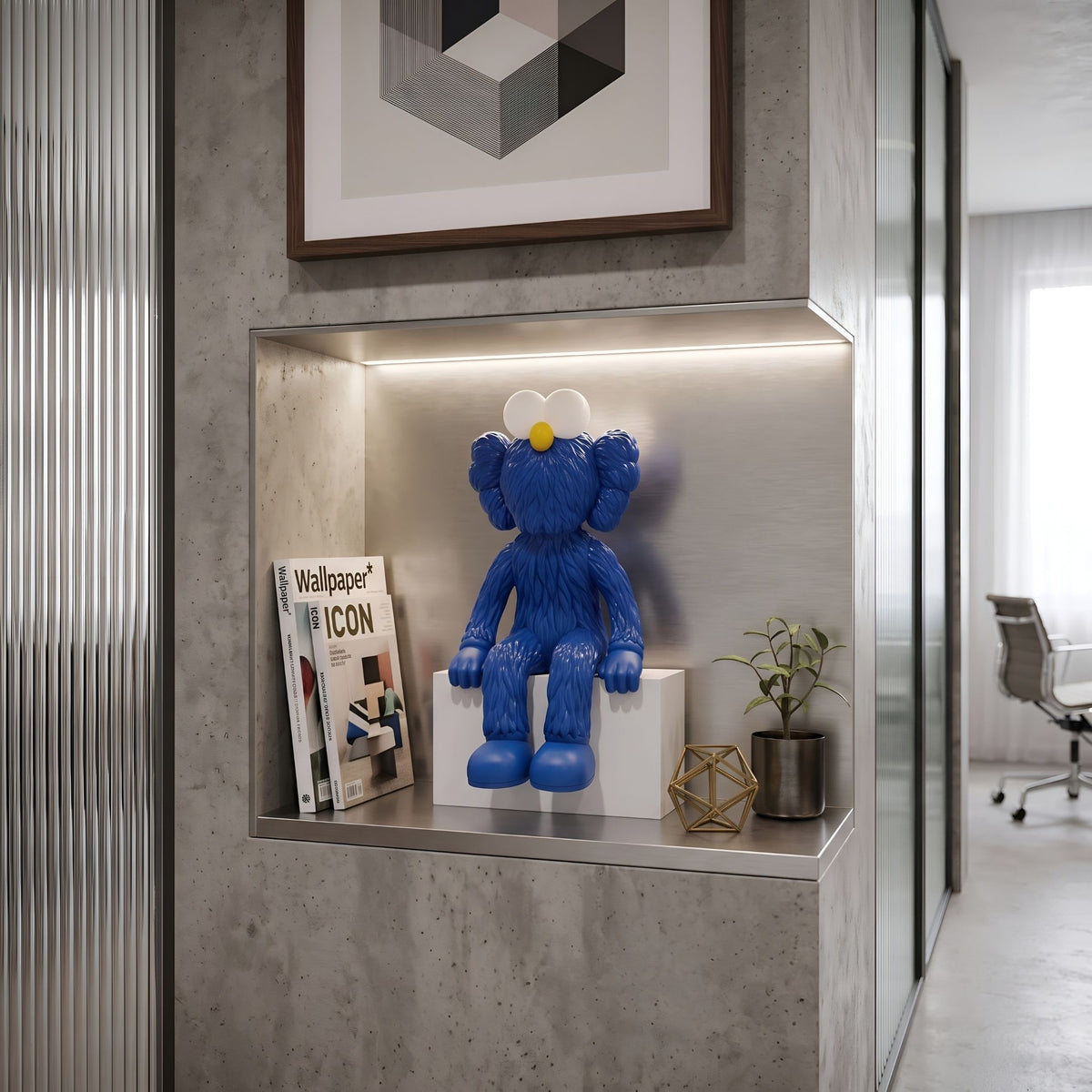 Deep Blue Iconify Furry Sitting Figure, 40cm, on a white plinth in a wall niche shelf with magazines, a potted plant, and framed art nearby.