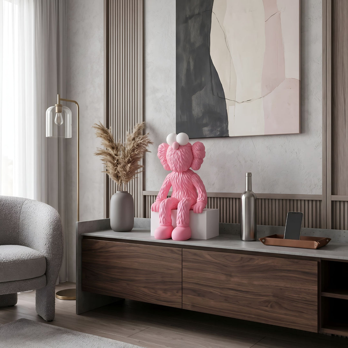 Petal Pink Iconify Furry Sitting Figure, 40cm, seated on a white block atop a media console in a living room with wood cabinetry and abstract wall art.