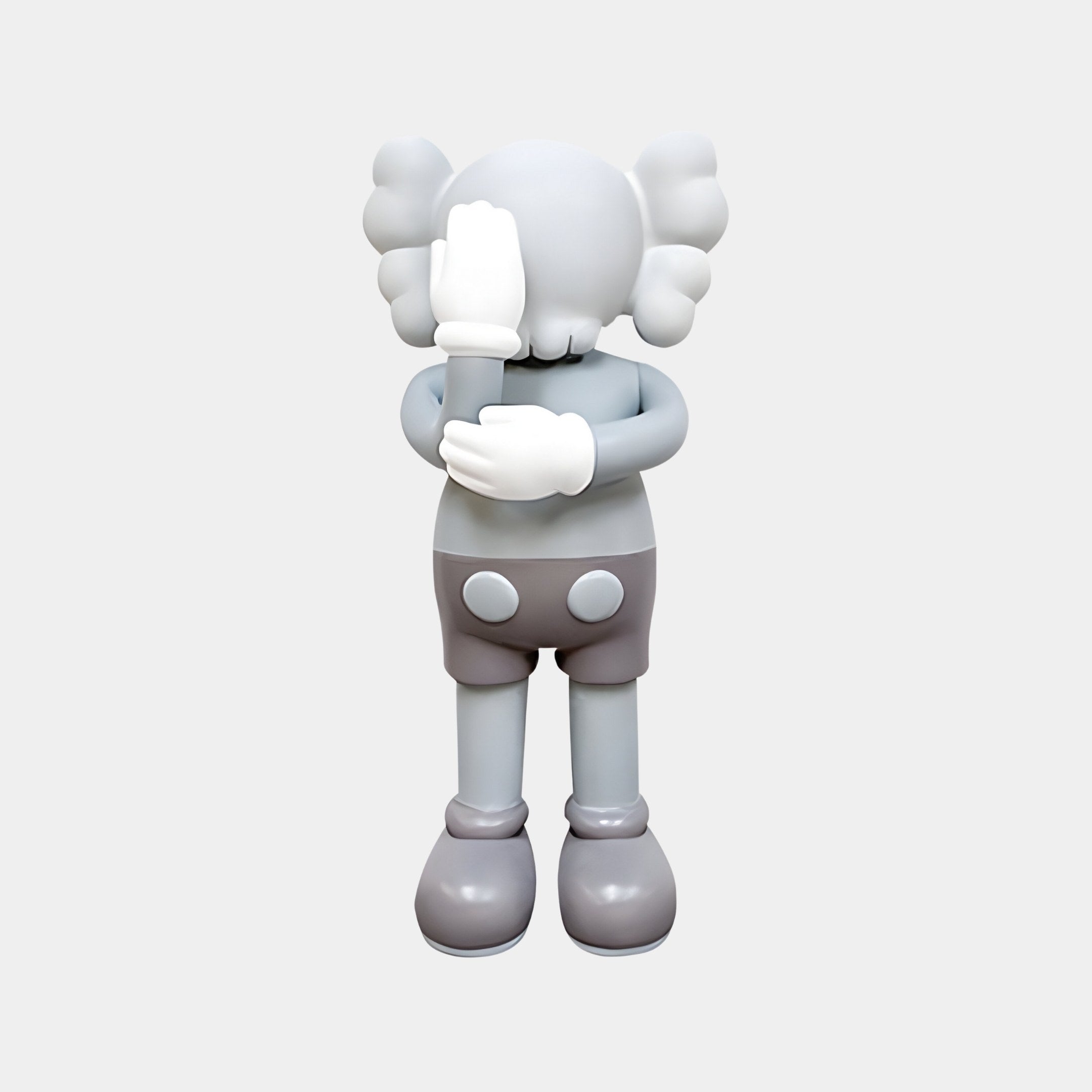 The Soft Grey Iconify III Dance Sculpture by Giant Sculptures is a 70cm piece featuring a cartoon-like figure with large ears, gloved hands covering its face shyly, wearing shorts and shoes against a plain white background, capturing the whimsy of modern art.