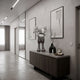 Soft Grey Iconify IV Dance Sculpture, 70cm resin figure with crossed arms, on a wooden sideboard in a modern hallway with framed wall art.