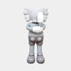 The Soft Grey Iconify IV Dance Sculpture by Giant Sculptures features a cartoon-like figure with a round head, X eyes, large bone-like ears, crossed arms, one gloved hand over its face, wearing shorts and large shoes against a plain backdrop. This contemporary sculpture stands 70cm tall.