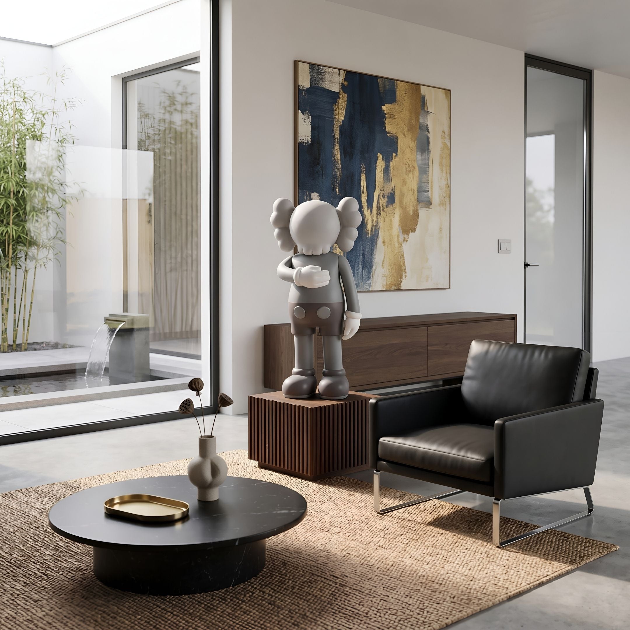 Soft Grey Iconify V Dance Sculpture, 70cm, on a wooden pedestal beside a black leather armchair and abstract wall art in a living room setting.