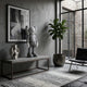 Soft Grey Iconify Standing Sculpture (70cm) displayed on a console table beside a ceramic vase, framed art, and a fiddle-leaf plant in a grey-toned living room.