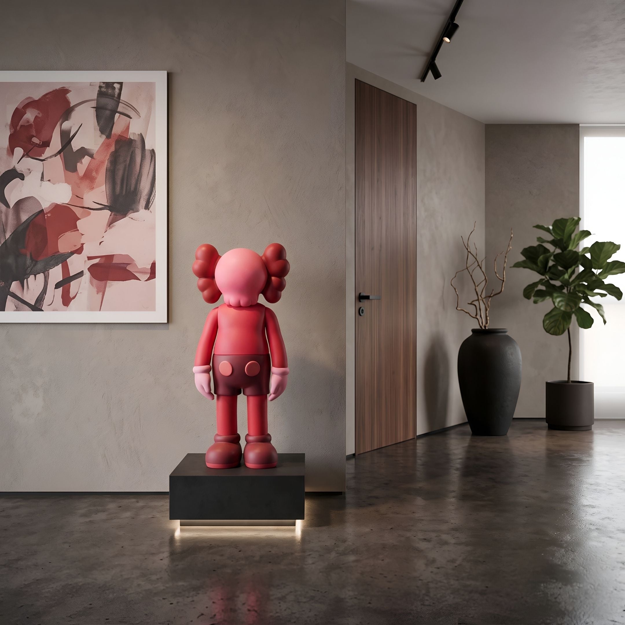 Blush Ruby Iconify Standing Sculpture, 70cm, on a black illuminated plinth in a hallway with abstract wall art and a green potted plant nearby.