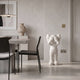 Cloud White Iconify Silent Cry Sculpture, 91cm, glossy white figure covering its face, displayed in a neutral dining room with dark chairs and a stone table.