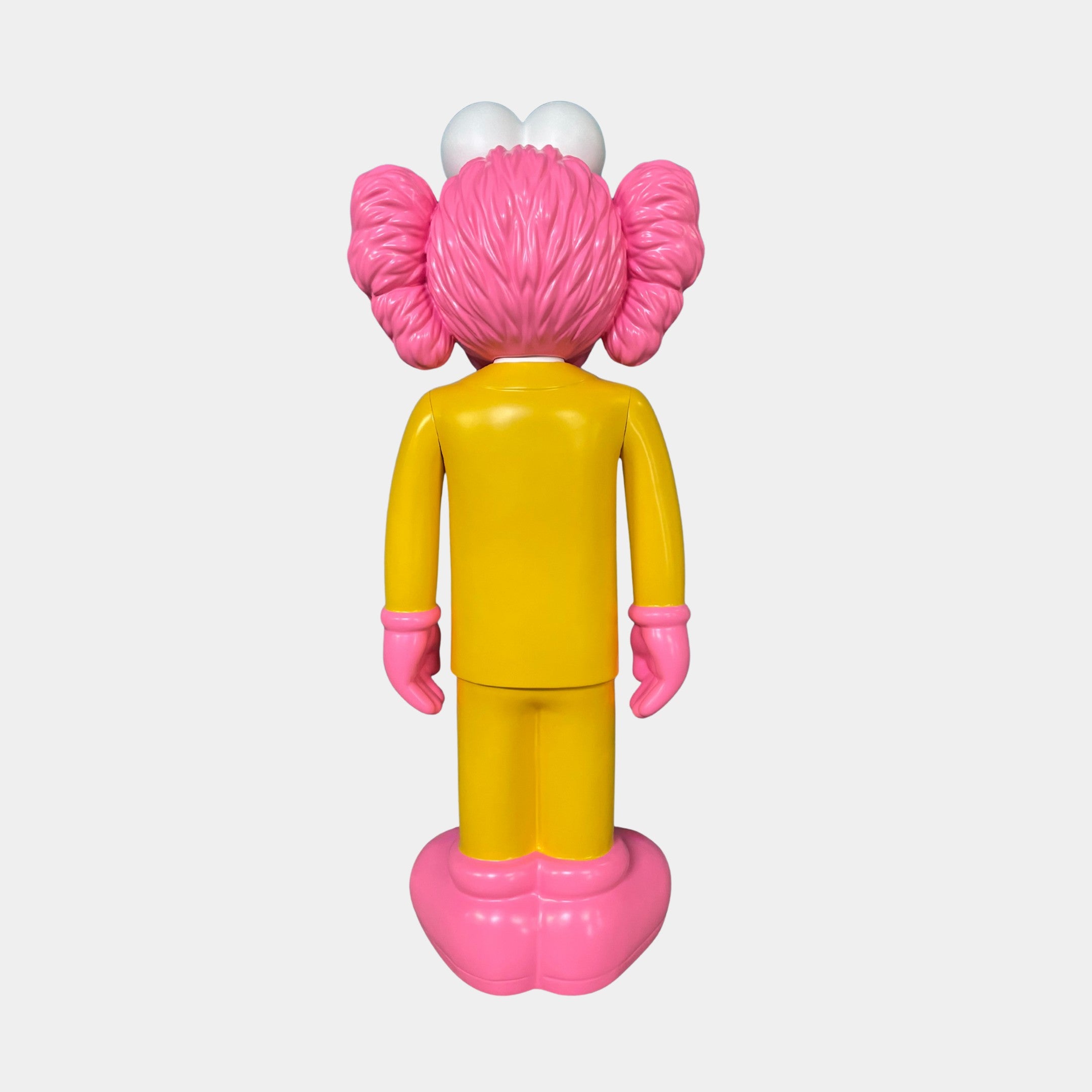 The Sunbeam Yellow Suit Iconify CEO Sculpture by Giant Sculptures (90cm) features a vibrant CEO in a yellow suit with pink hair, gloves, and shoes—an eye-catching resin piece ideal for luxury workspace decor.