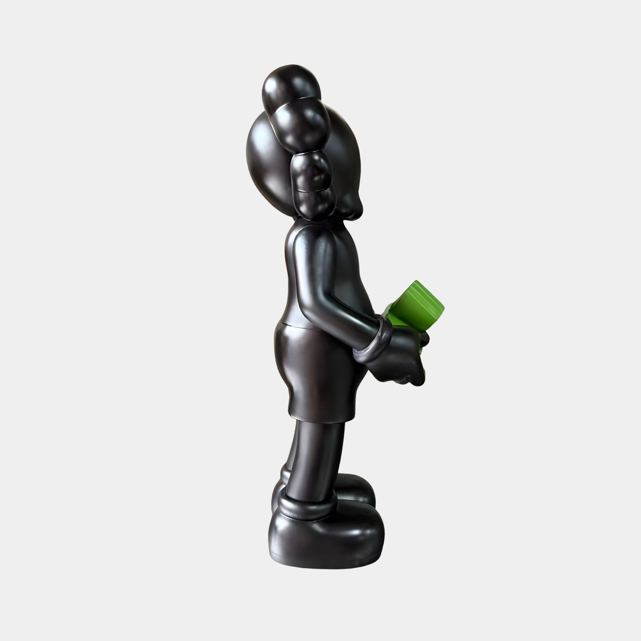 Side view of the Giant Sculptures Midnight Black Iconify Dollars Figure (30cm) in polyvinyl, holding a green dollar stack, shown on a plain light background.