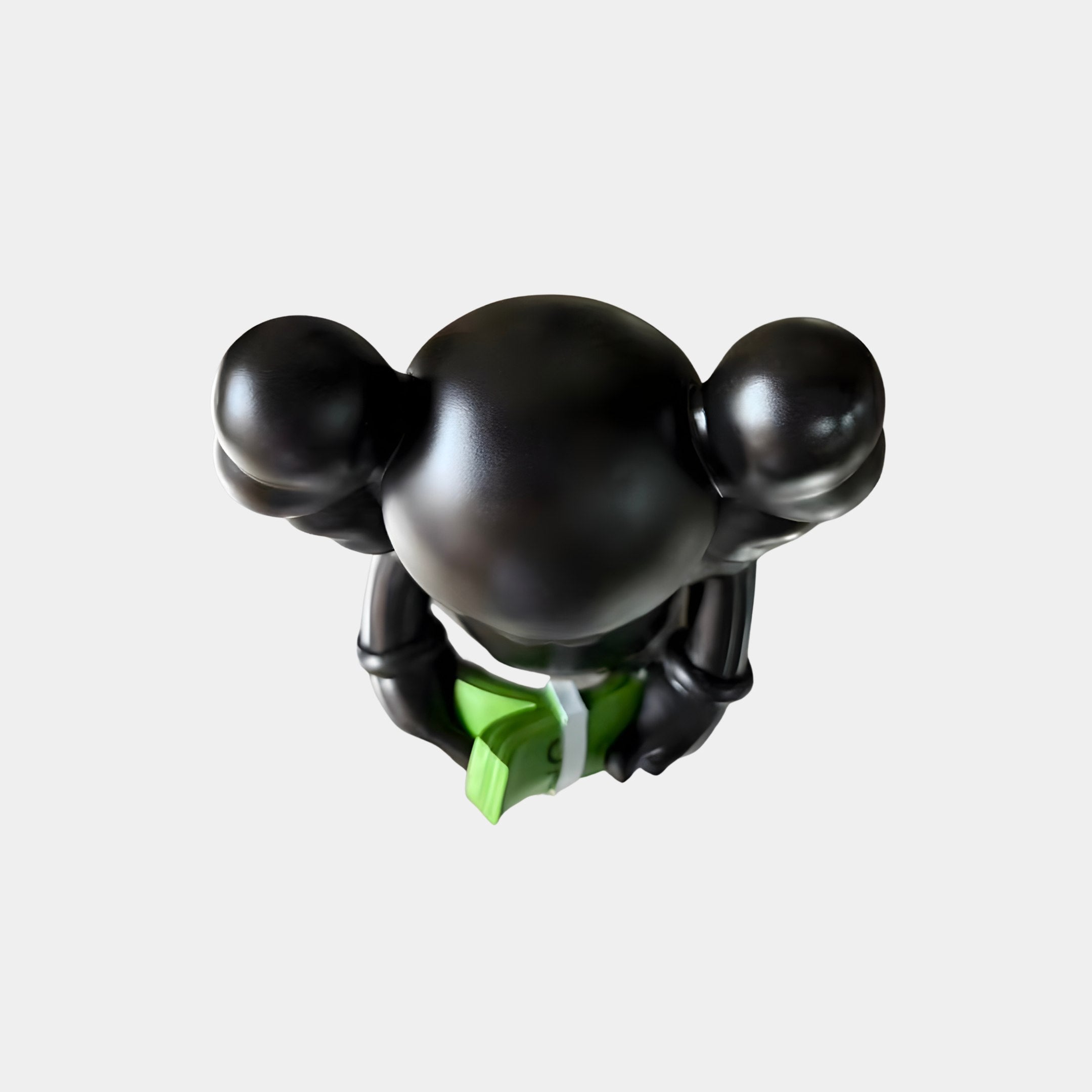 Top-down view of the Midnight Black Iconify Dollars Figure 30cm by Giant Sculptures, showing the glossy black head and shoulders cradling a green dollar stack.