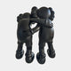 Two black cartoon-like figures stand in a warm embrace. The Midnight Black Iconify Friendship Sculpture - 150cm by Giant Sculptures is perfect for modern resin sculpture collections or contemporary art displays.