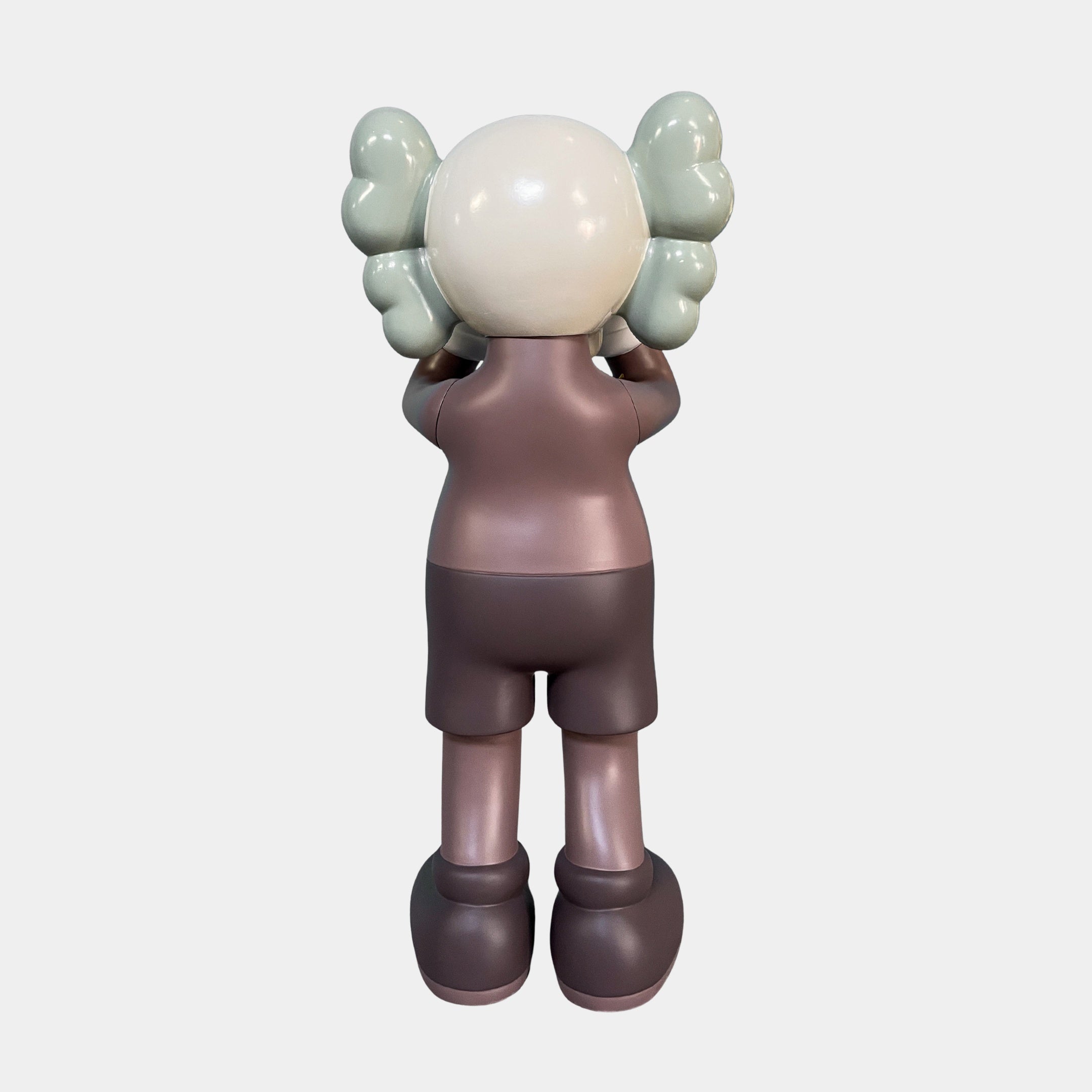 The Hazelnut Brown Iconify Silent Cry Sculpture (91cm) by Giant Sculptures features a stylized cartoon figure with gray puffy hair and hazelnut brown clothing, standing with hands covering its face—ideal for contemporary art decor.