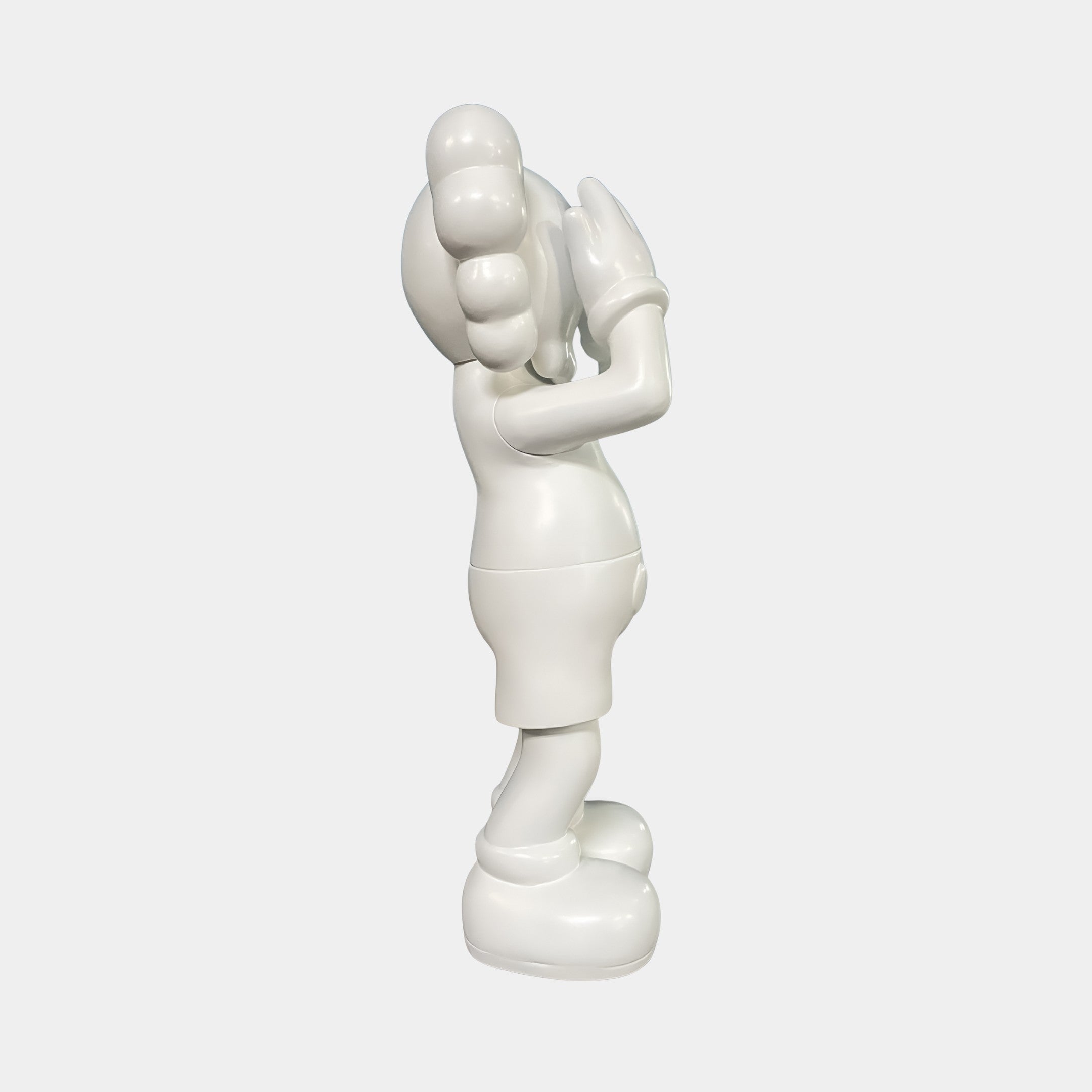 The Cloud White Iconify Silent Cry Sculpture - 91cm by Giant Sculptures stands upright in profile, featuring large gloves, oversized shoes, and round forms with hands covering its face—a striking piece of modern decor.