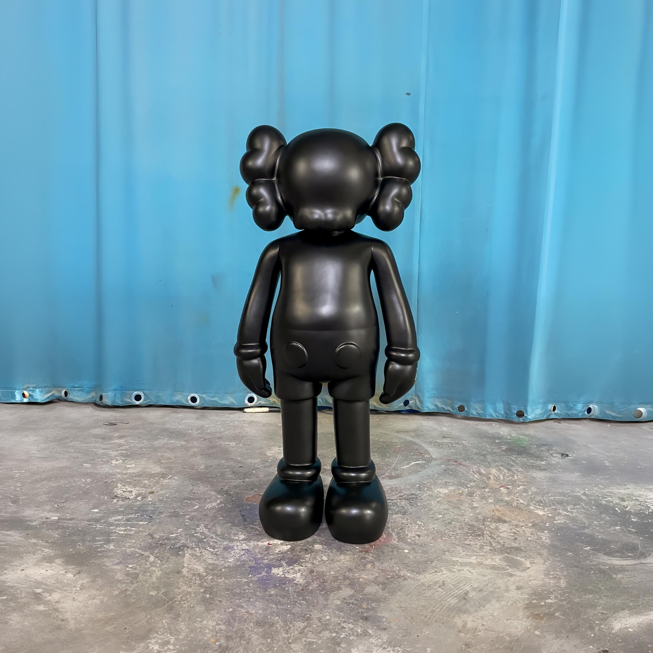 Rear view of the Giant Sculptures Midnight Black Iconify Standing Sculpture 130cm, showing its rounded ears and smooth matte silhouette against a blue backdrop.
