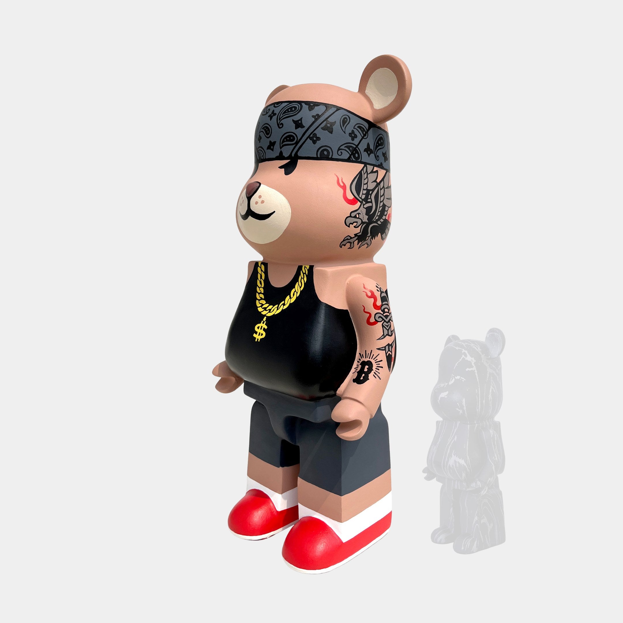 A limited edition from Giant Sculptures, the Iron Paw Bear Sculpture - 50cm features a street-style cartoon bear with a black bandana, gold chain, tattoos, red sneakers, face tattoo, and a semi-transparent bear behind it.