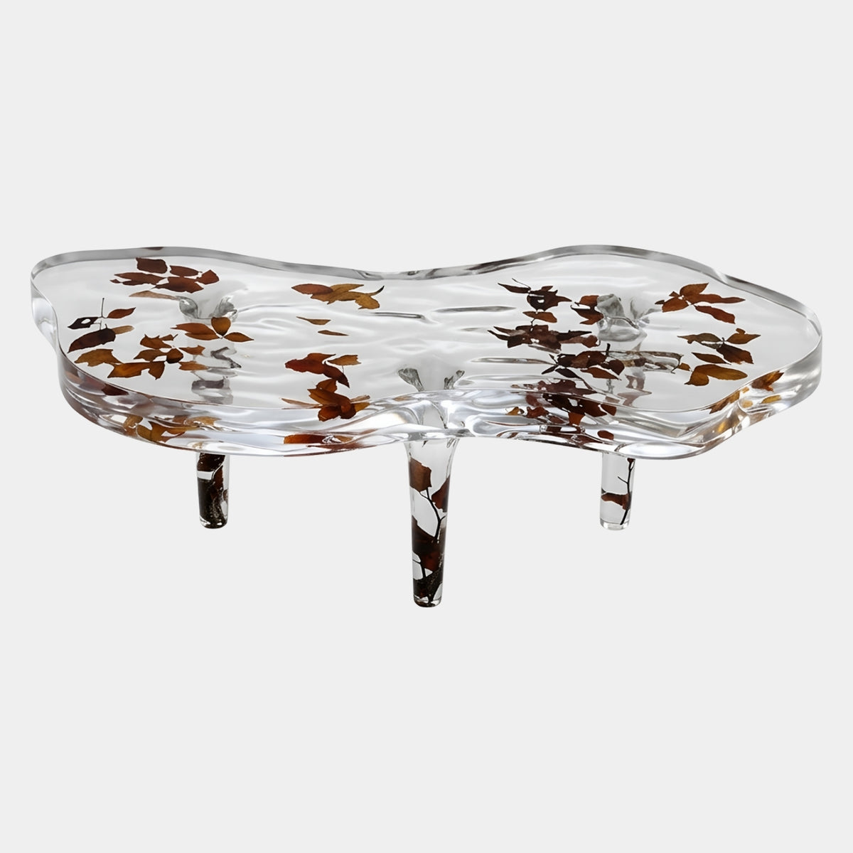 Clear Autumn Leaf Resin Coffee Table, 130cm, with an irregular wavy-edged top on three tapering legs embedding rust and amber leaf forms, shown on a plain white background by Giant Sculptures.