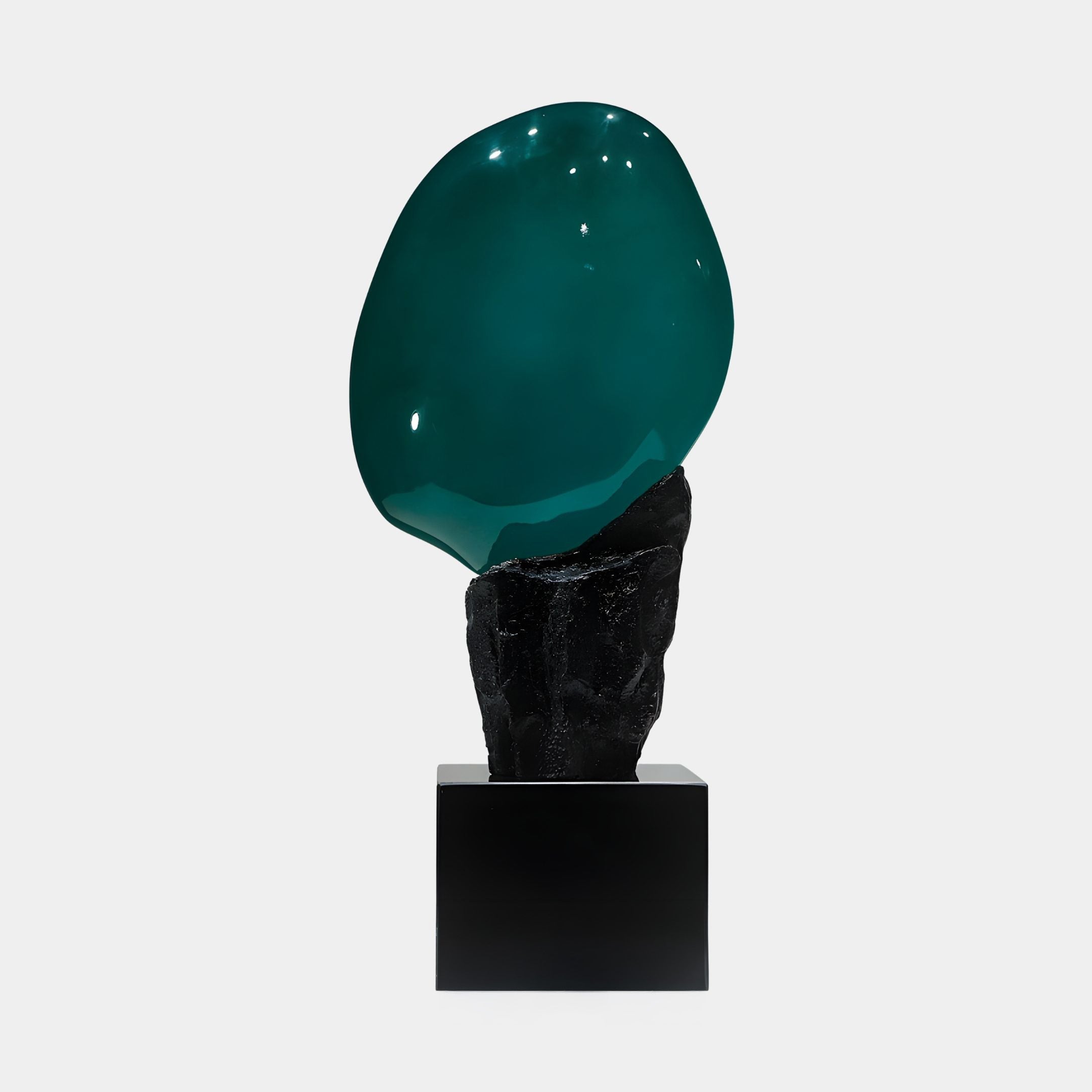 Giant Sculptures Teal Resin Orb on Black Stone Base Sculpture, featuring a glossy teal-green orb resting on a rugged black stone plinth against a plain white background.