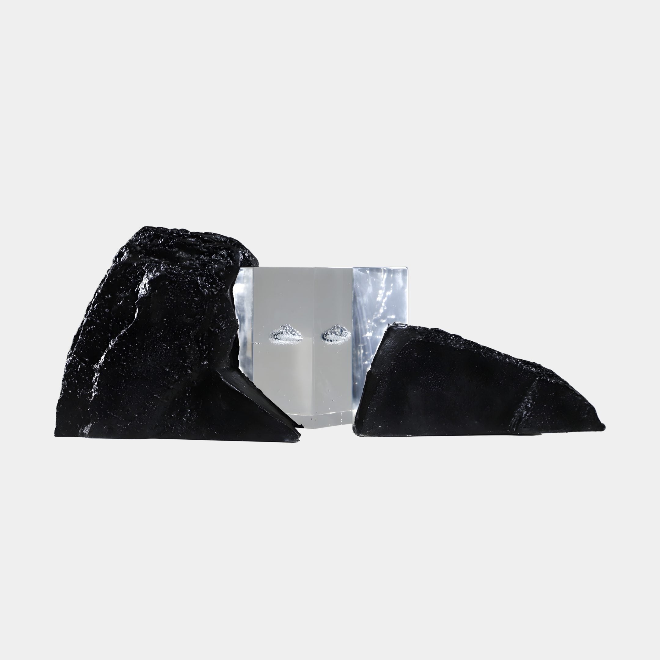 Clear Resin Cube & Dual Black Rock Sculpture by Giant Sculptures, featuring a transparent angular cube wedged between two rugged black rocks on a white background.