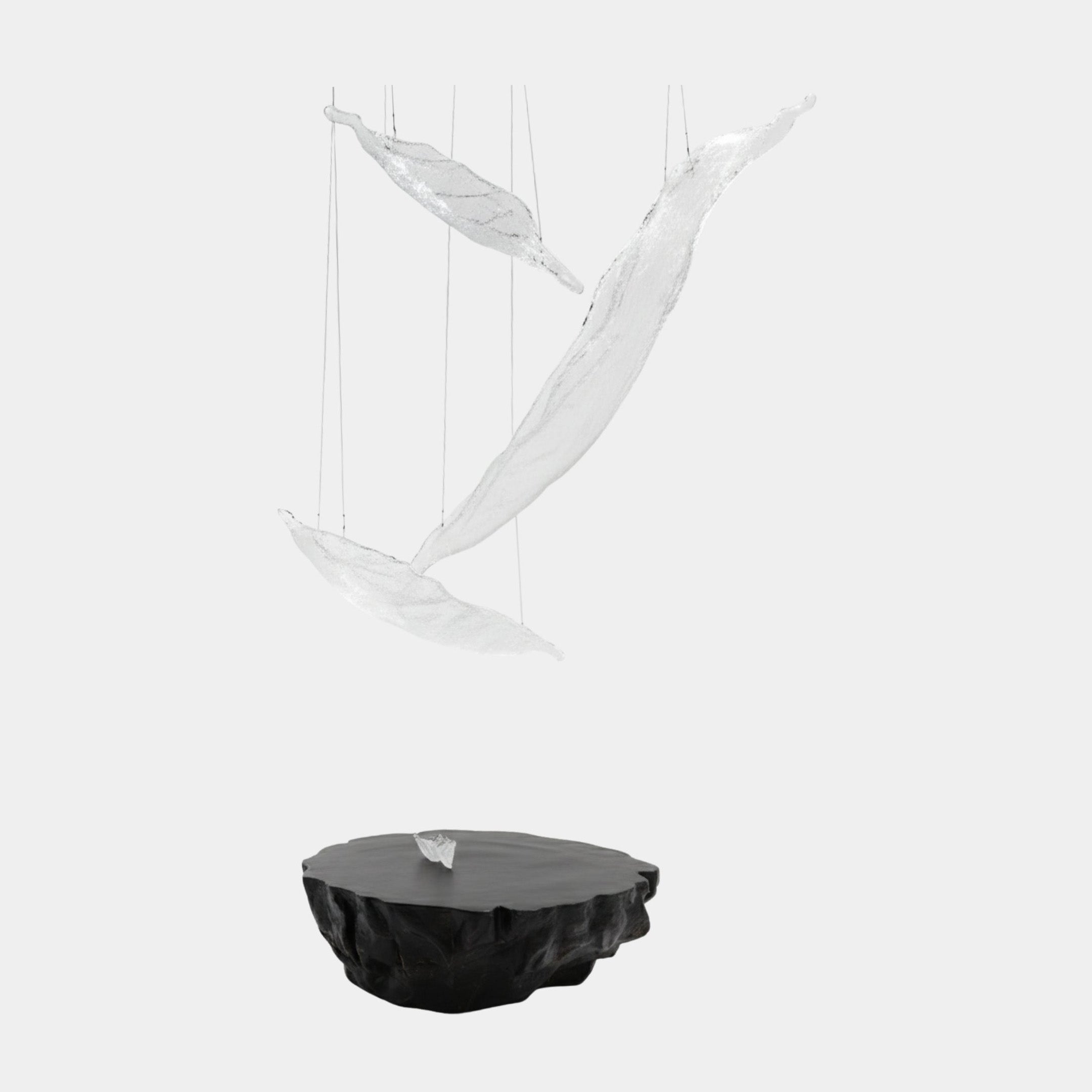 Giant Sculptures Crystal Clear Suspended Bird Set with three frosted translucent fibreglass forms hanging on fine threads above a dark sculpted rock base.