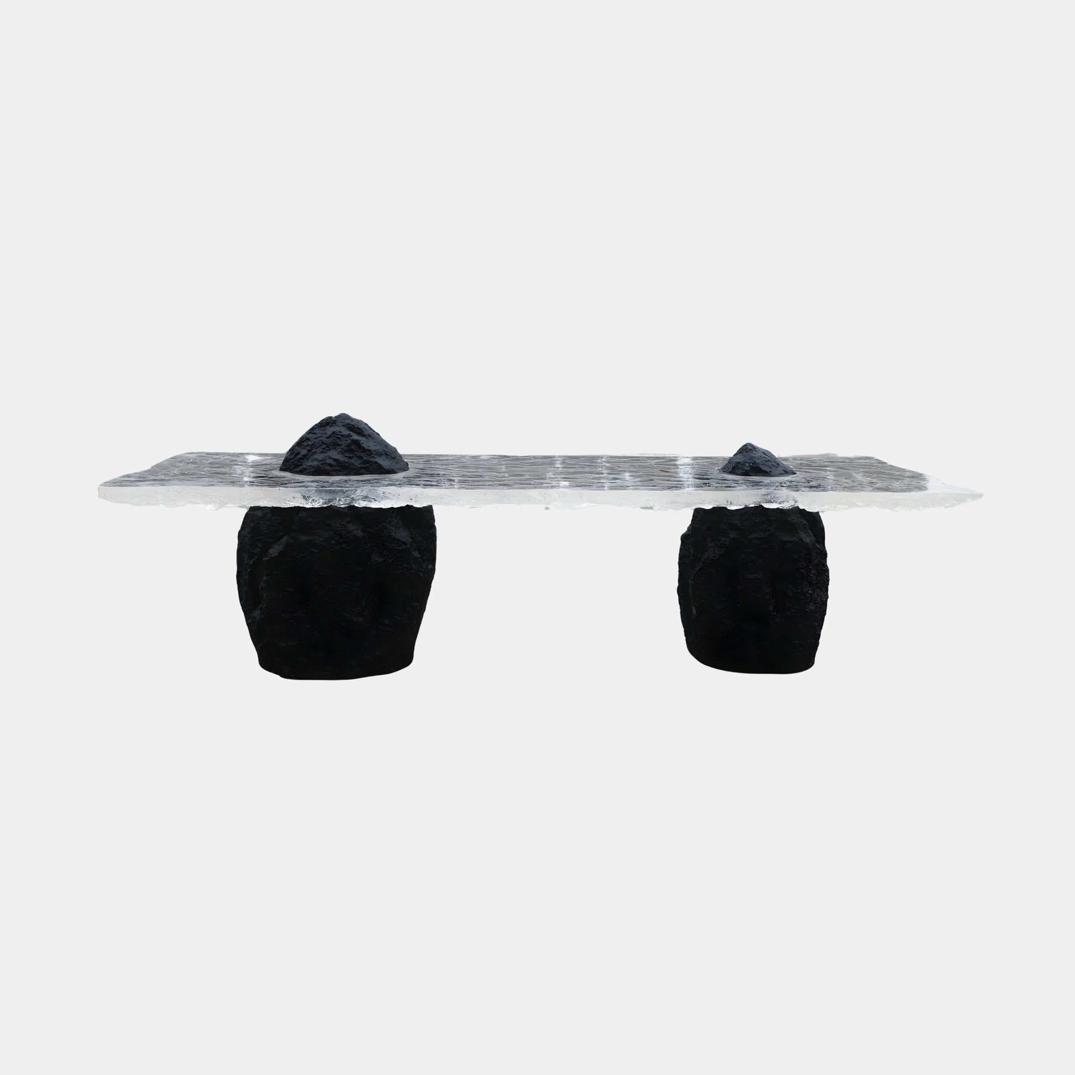 Giant Sculptures Clear Resin Slab on Black Rock Console Bench 300cm with a transparent textured top resting on two rugged black rock legs, plain white background.