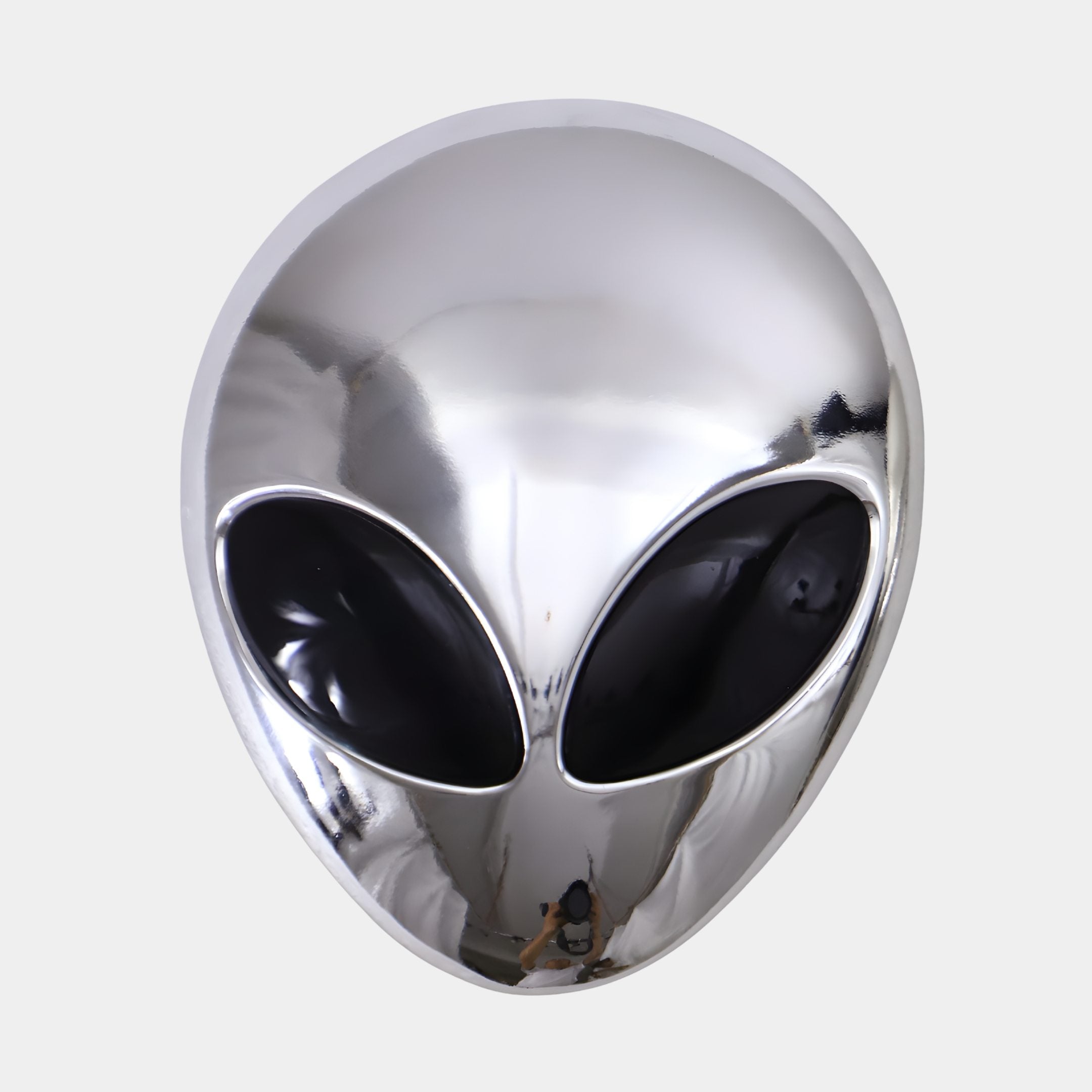 Polished Chrome Alien Head Wall Sculpture by Giant Sculptures, front view showing the mirror-finish silver dome and large black almond eyes on a plain grey background.
