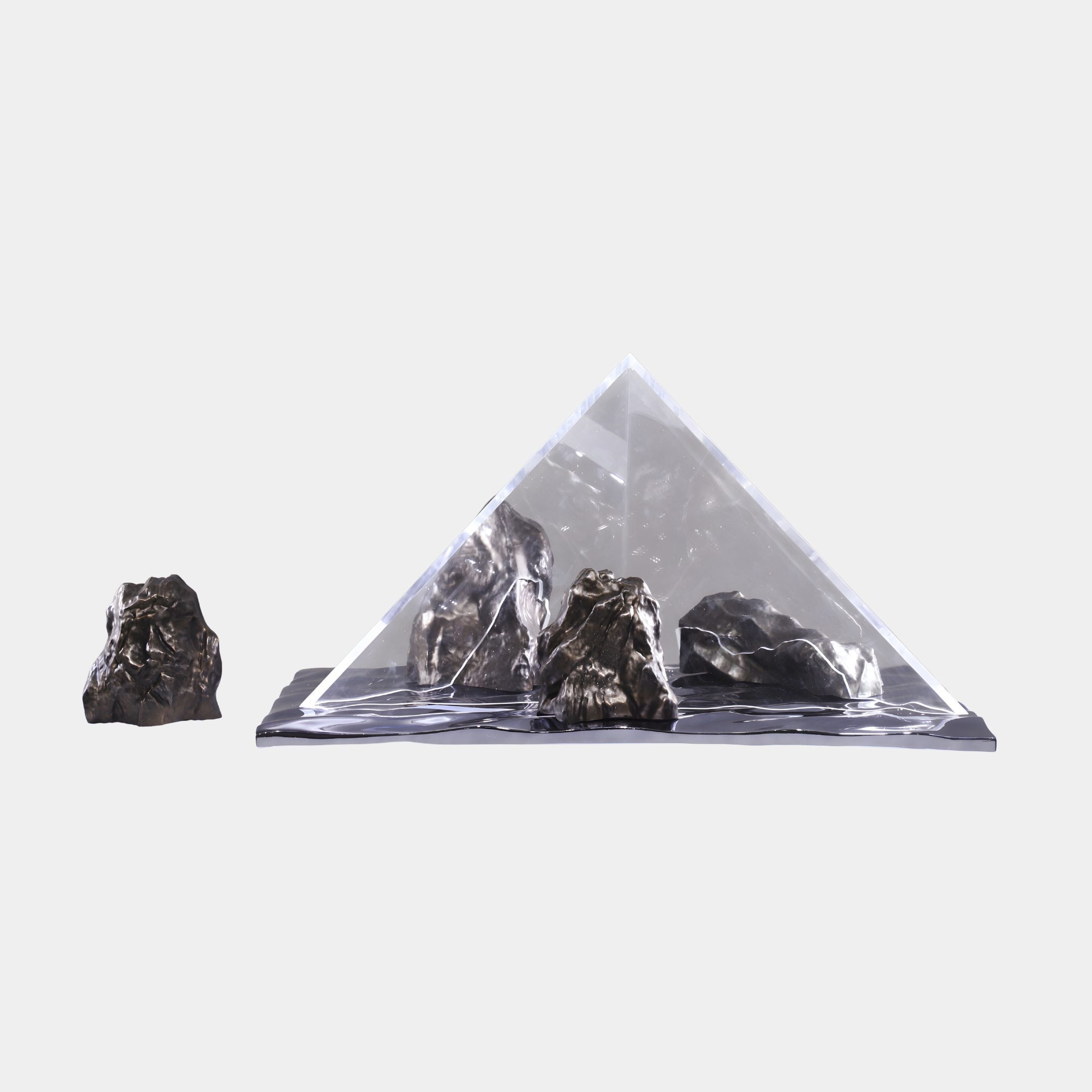 Giant Sculptures Clear Resin Triangle with Rocks Sculpture 130cm, a transparent pyramid over dark fibreglass rocks beside a separate stone, on a plain background.