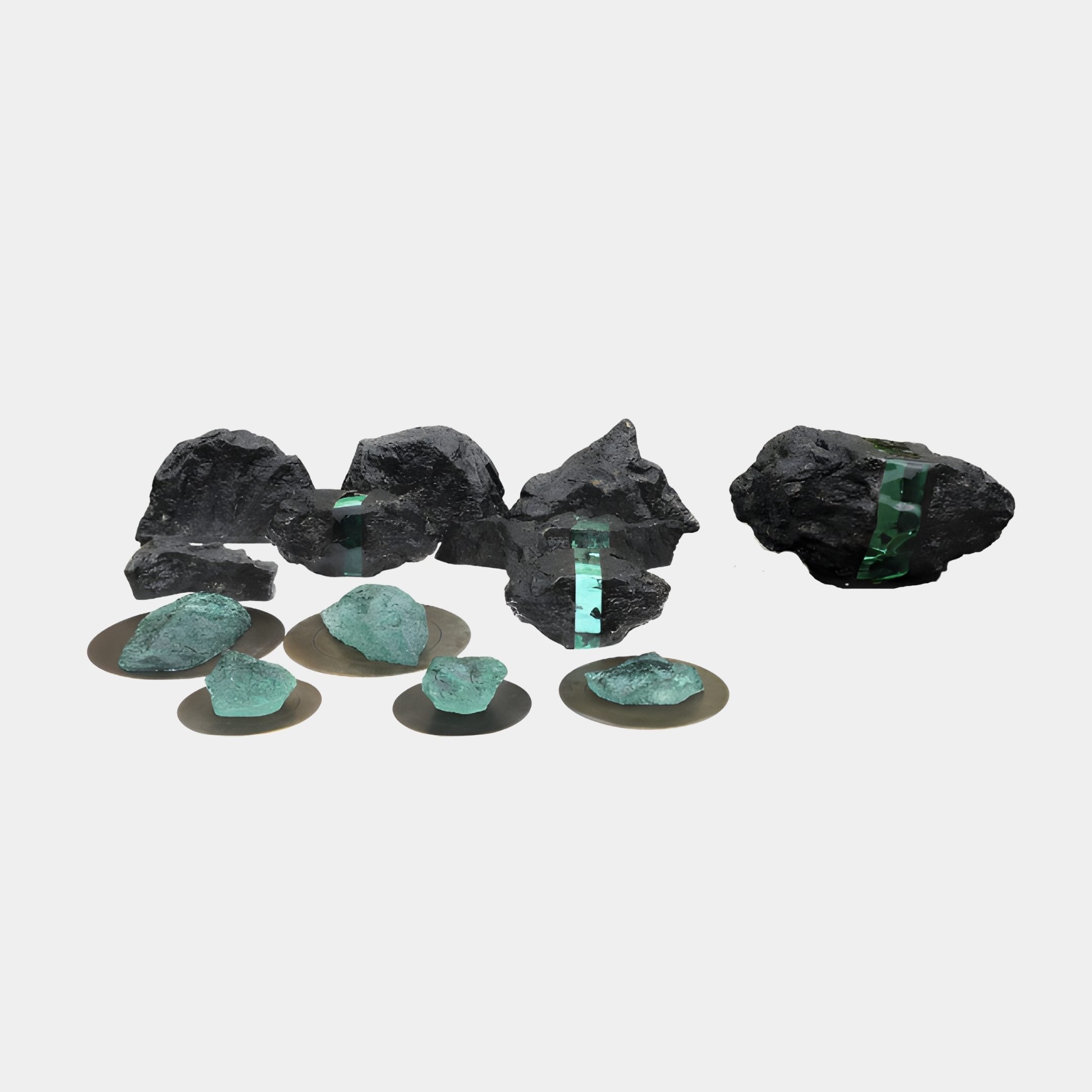 Giant Sculptures Black Rock with Teal Resin Inset Sculpture set, featuring rugged black stones with glowing green resin pools and smaller polished pebbles on metallic discs.
