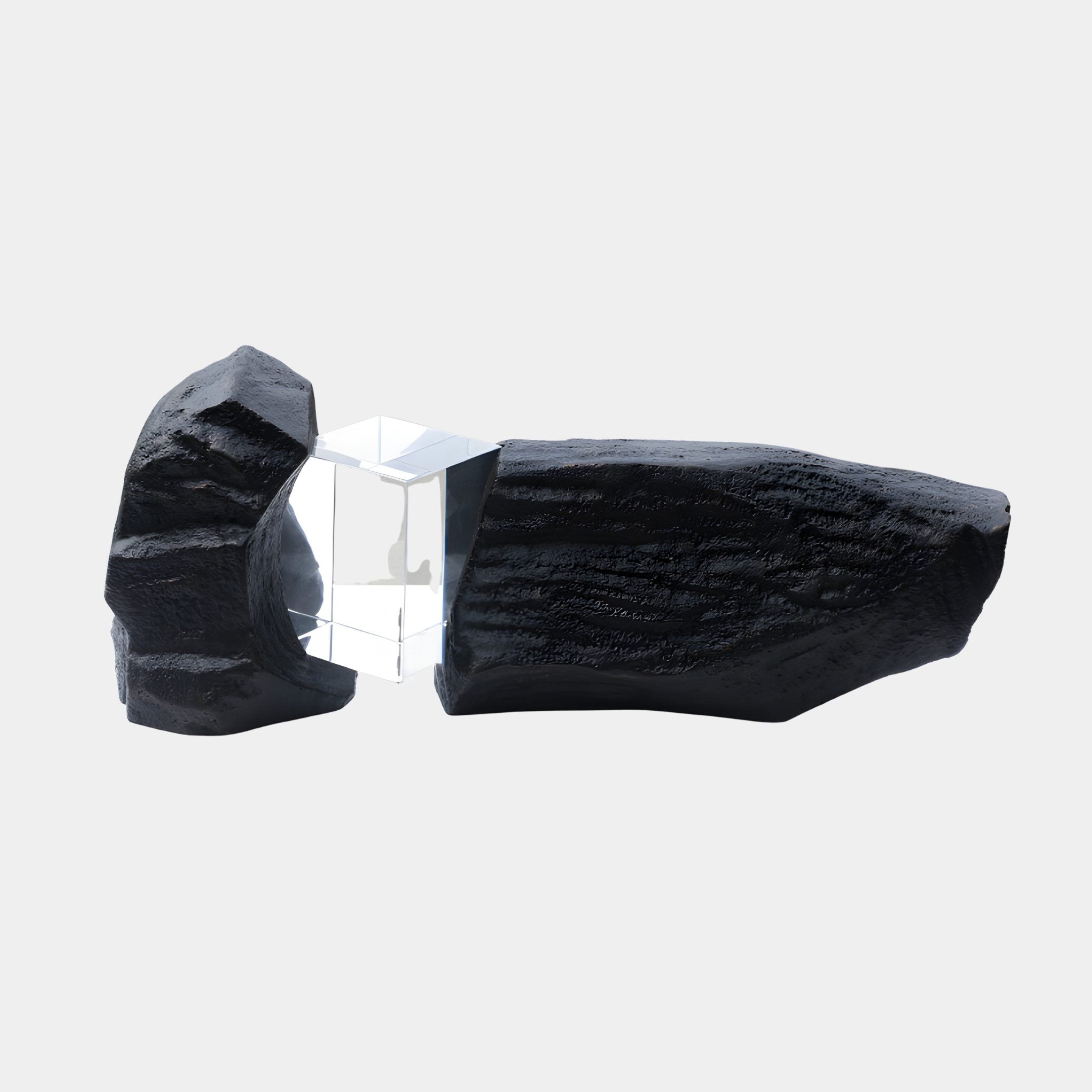 Clear resin prism nestled between two textured black fibreglass boulders forming the 135cm Giant Sculptures pair, shown on a plain light background.