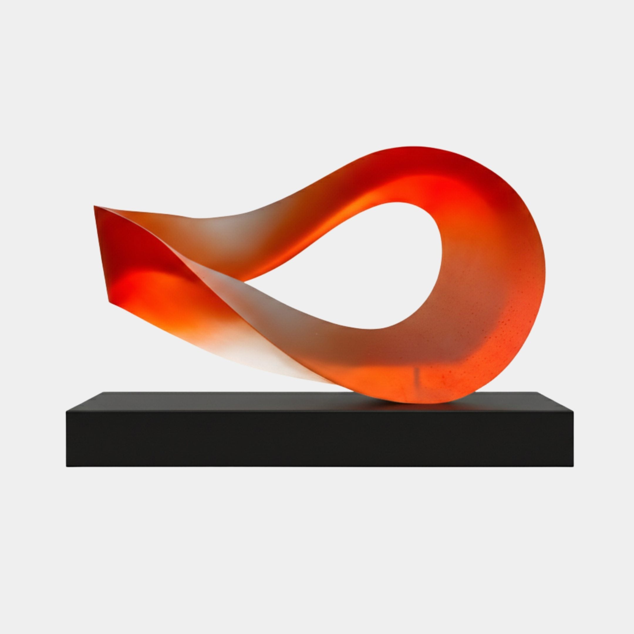Sunset Orange Resin Floating Loop Sculpture by Giant Sculptures, a translucent ribbon twisting into a flowing loop on a slim black base against a white background.