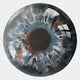 A close-up of a glass marble with a black core and swirling blue, white, and brown tones—an abstract eye that inspires the Genesis Ember Glow 3D Resin Crystal Porcelain LED Wall Art by Giant Sculptures.