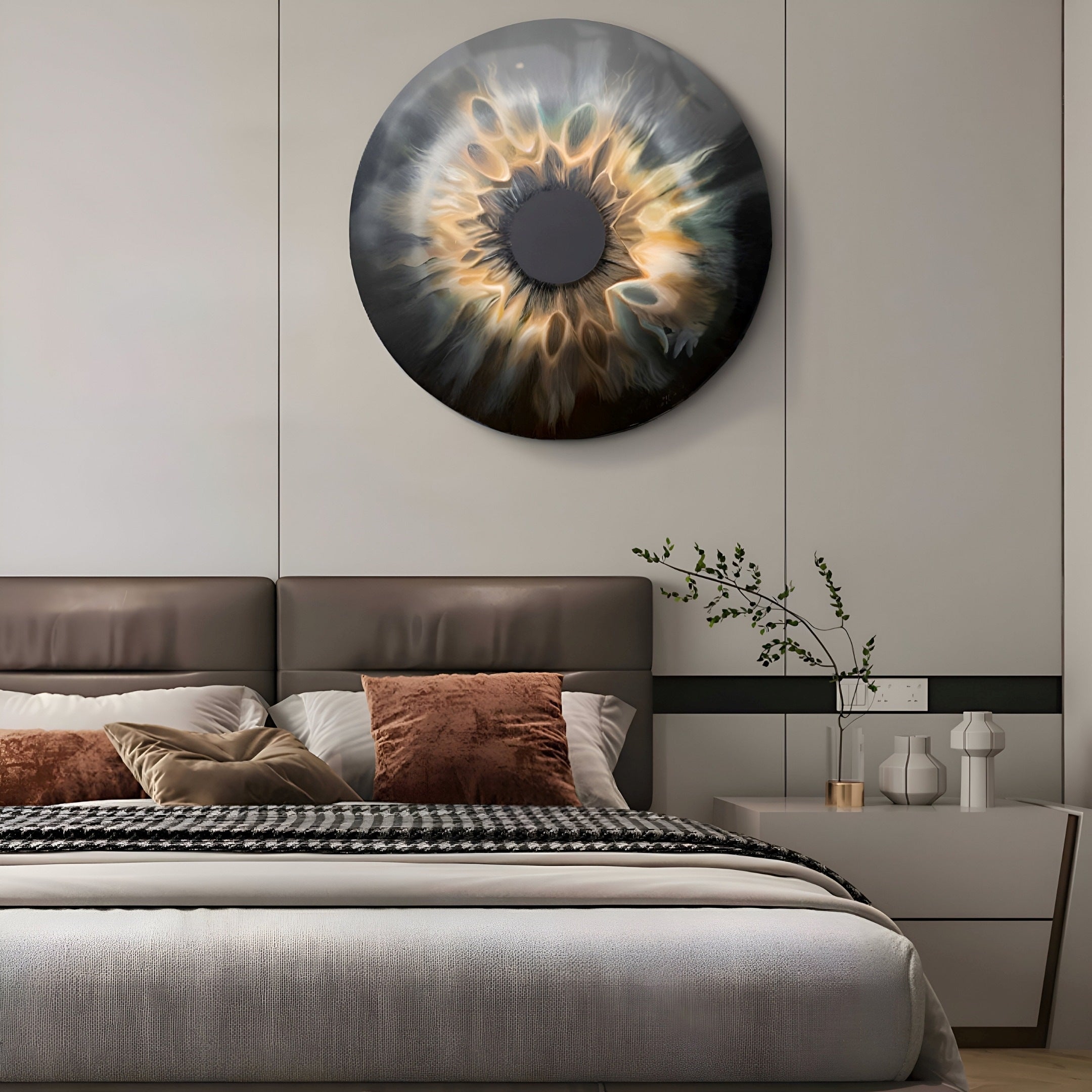 A modern bedroom showcases the Genesis Golden Halo 3D Resin Crystal Porcelain LED Wall Art by Giant Sculptures above the bed, with its swirling dark and light pattern. The brown and white bed, enhanced by throw pillows, harmonizes with a plant on the nightstand to create a captivating ambiance.