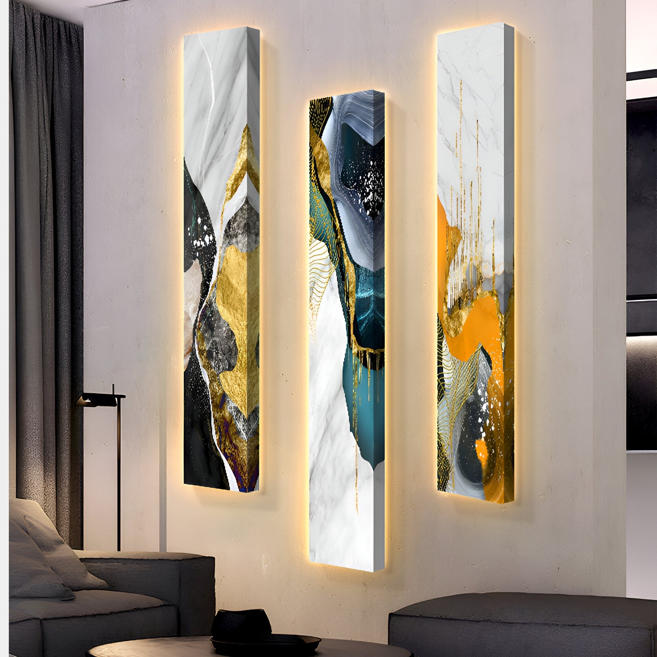 Three vertical panels of the Floren Oceanic Drift Canvas LED Wall Art by Giant Sculptures hang on the wall, featuring flowing designs in white, gold, black, teal, and orange. The art casts a warm glow onto a modern sofa and floor lamp for a contemporary living room setting.