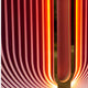 Close-up of Giant Sculptures Onyx Flame Glow Acrylic 3D LED Wall Art featuring modern curved, parallel vertical lines. It emits a gradient from dark red to bright orange with a glowing effect and symmetrical pattern, highlighted by a metallic texture in the center.