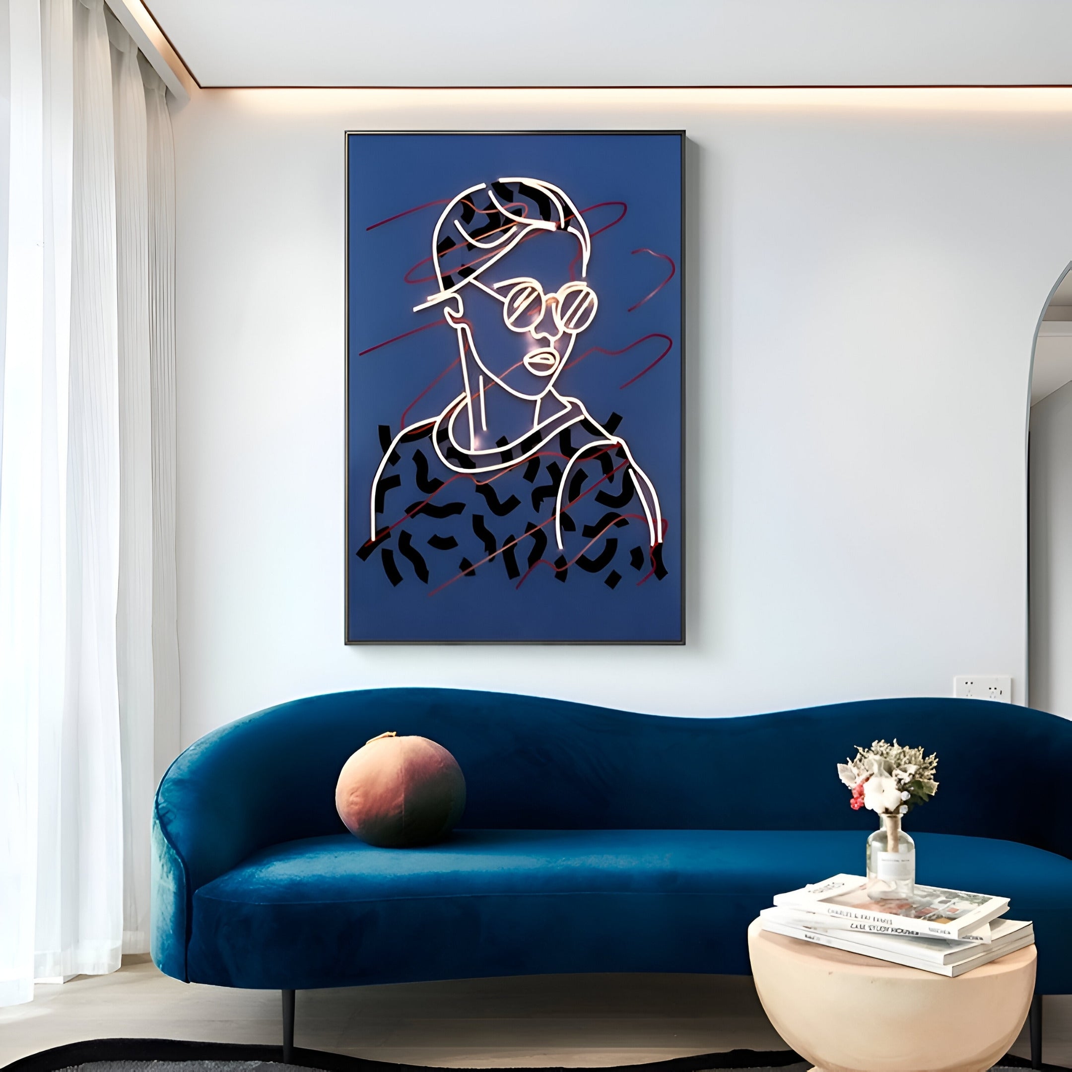 A modern living room with a blue velvet couch, a small round coffee table holding pink and white flowers, and Giant Sculptures Polaris Urban Vogue Crystal Porcelain 3D LED wall art featuring an abstract portrait of a person in sunglasses and a cap.