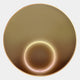 The Aurora Golden Halo Crystal Porcelain LED Wall Art by Giant Sculptures features a round, gold-colored disc with a glowing central LED ring, its minimalistic modern design reminiscent of an elegant golden halo. Set against a plain white background.