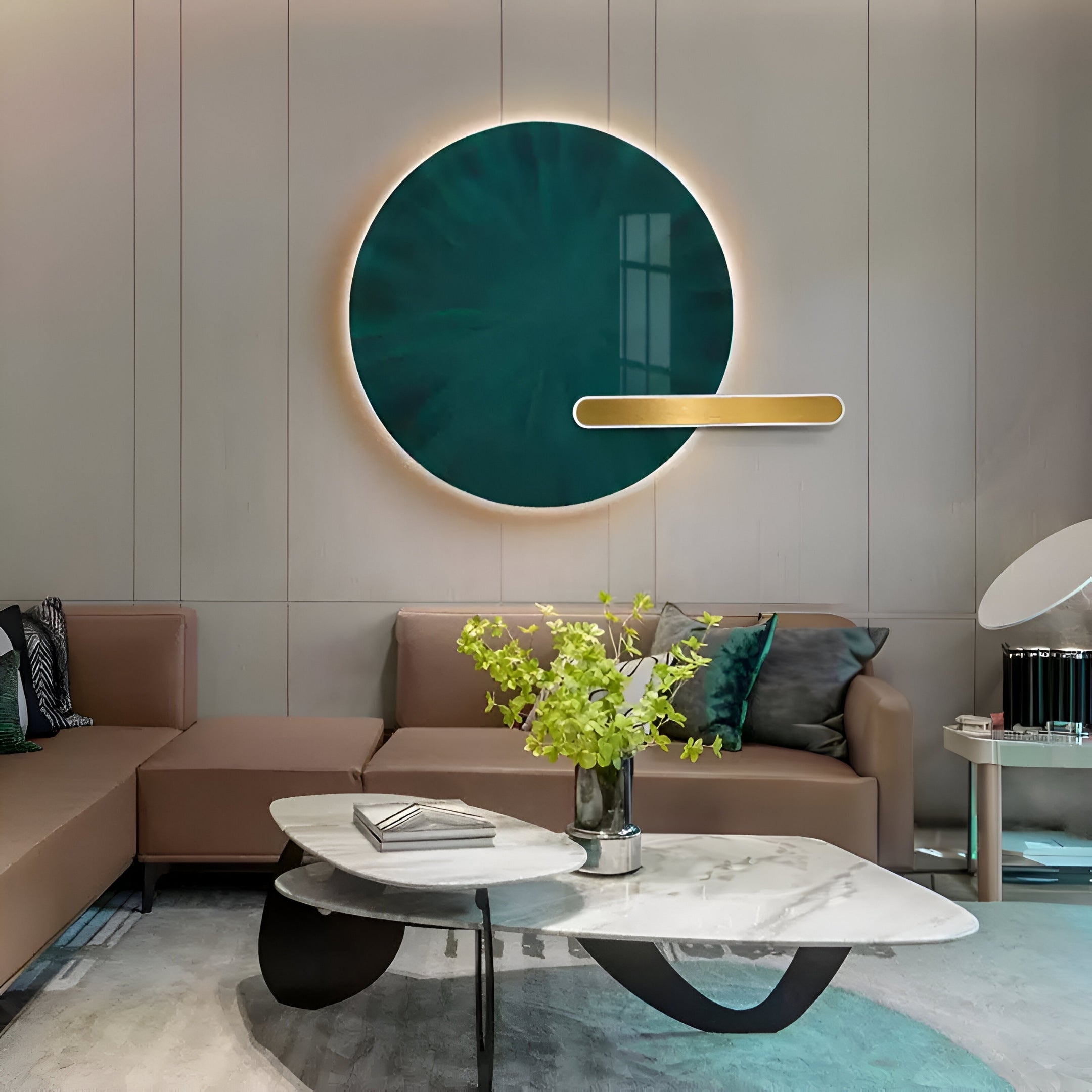 A modern living room features a brown sofa beneath the Lumea Jade Green 3D LED Crystal Porcelain Wall Art by Giant Sculptures. A marble coffee table with greenery sits in front, complemented by soft lighting, neutral walls, and contemporary decor elements.