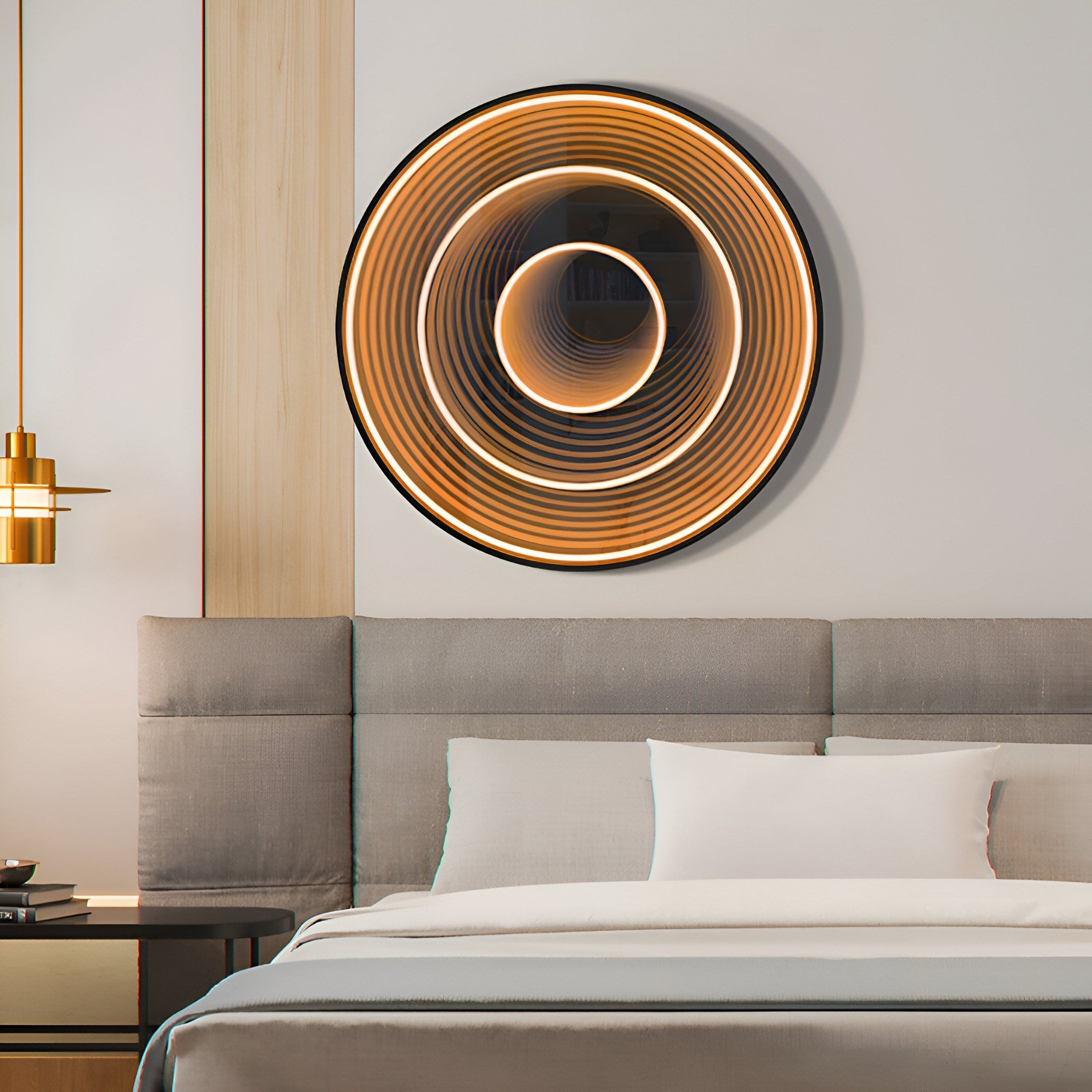 In a modern bedroom, the Reflex Gold Mirror 3D LED Wall Art by Giant Sculptures shines above the bed, displaying radiant concentric rings. The rooms elegance is enhanced by luxury wall decor, a neutral color palette, and a grey headboard next to the pendant light.