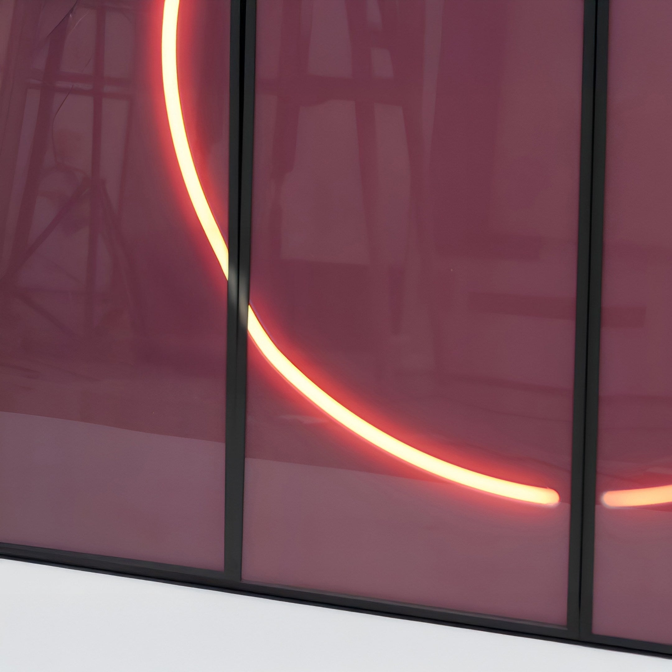 The Enigma Rosewood Glow LED Wall Art by Giant Sculptures emits warm white neon light through a translucent pink wall with vertical dark frames, softly illuminating the room and hinting at abstract shapes within its contemporary style.