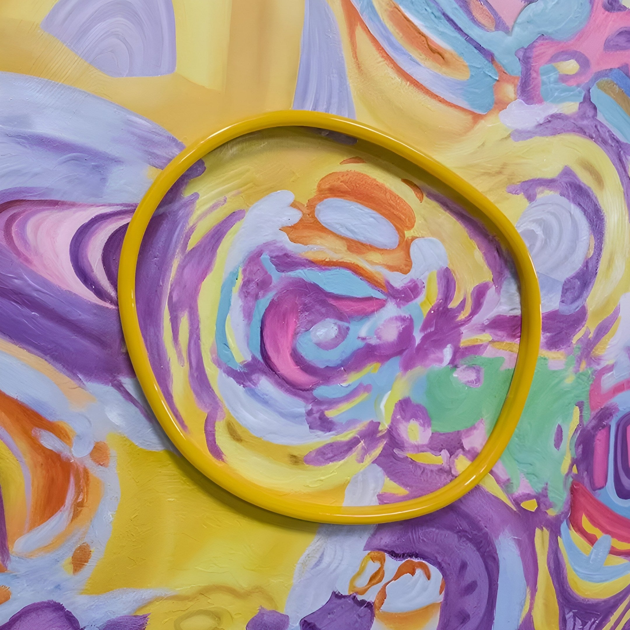 The Elysian Chromatic Vortex Oil Painting 3D LED Wall Art by Giant Sculptures displays vibrant swirls of purple, yellow, pink, orange, and green. A yellow circular frame adds a playful focal point to the lively abstract canvas.