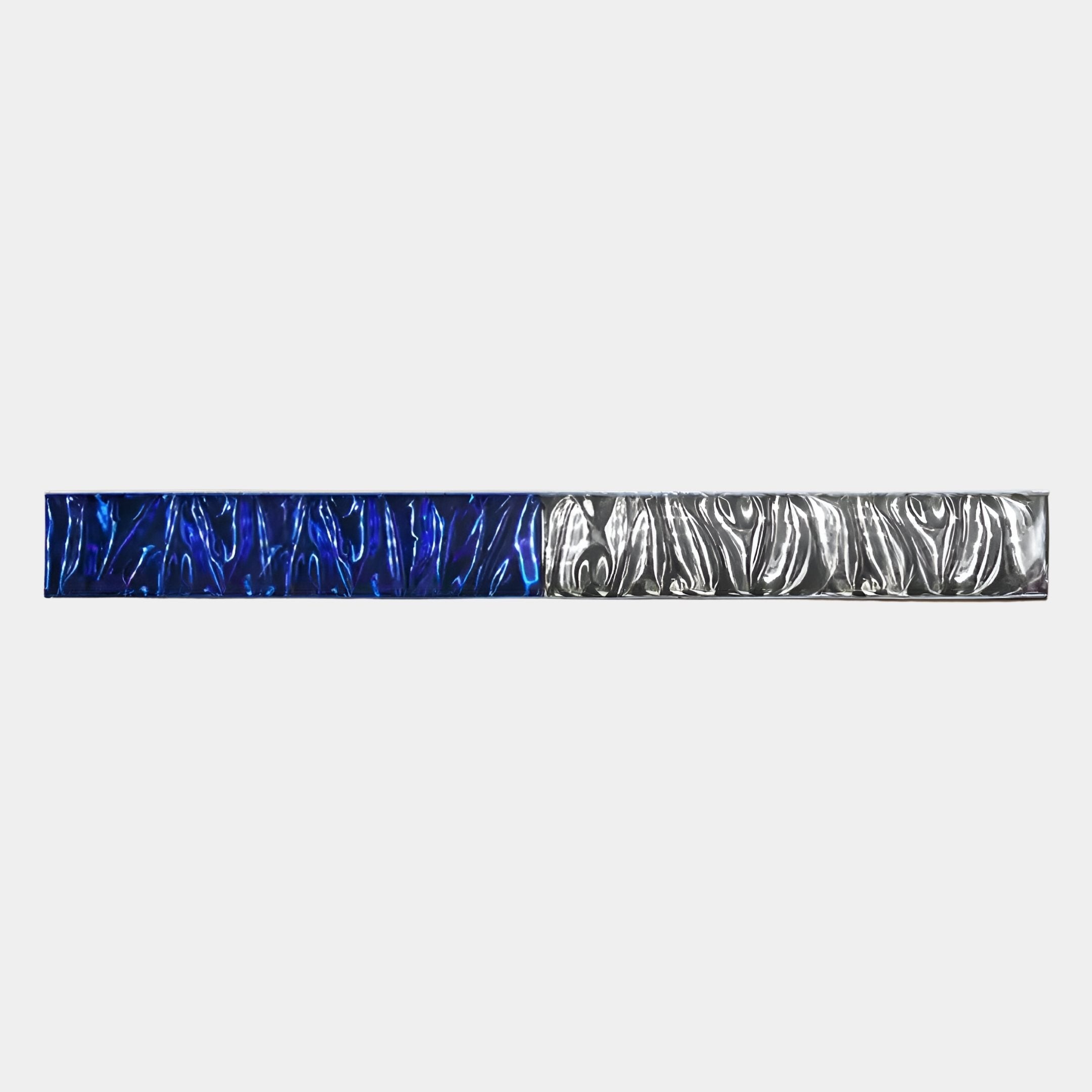 The Textura 3D Blue And Silver Leather Design Wall Art by Giant Sculptures features a horizontal metallic bar with a wavy texture, half in blue and half in silver, creating modern elegance against a plain light gray background.