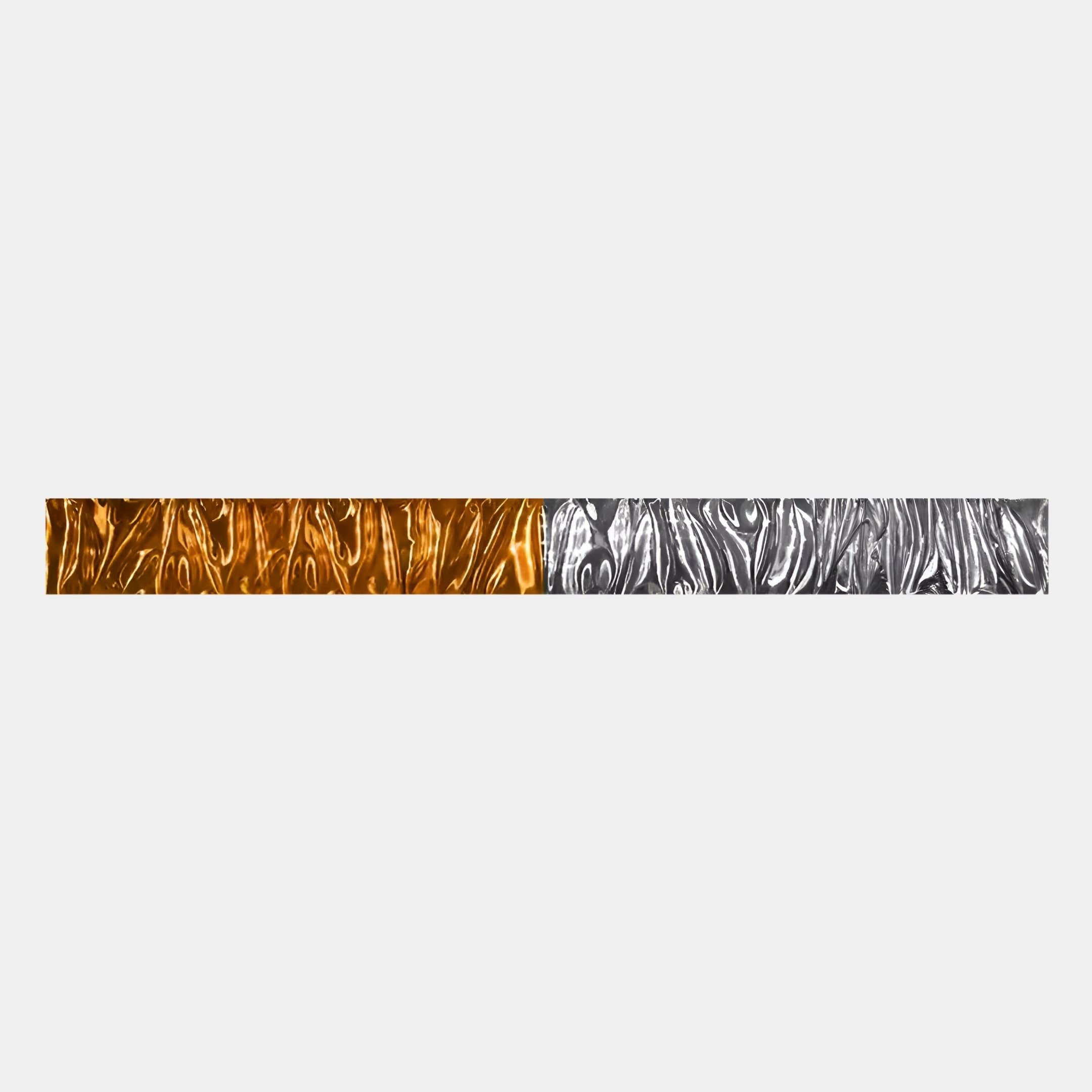 The Textura 3D Amber And Silver Leather Design Wall Art by Giant Sculptures features a long, narrow strip with a wavy texture—metallic gold on the left, silver on the right—adding modern flair to any space against a light gray background.