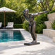 Large Contemporary Diving Athlete Bronze Sculpture by Giant Sculptures at 180cm, posed mid-launch on a dark base beside a poolside patio with loungers.