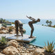 Giant Sculptures Large Modern Abstract Diver Figures Bronze Sculpture 160cm poolside on a stone platform, one figure bent forward, the other poised to dive, ocean beyond.
