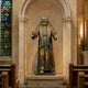 Large Traditional Robed Friar Saint Bronze Statue by Giant Sculptures, 150cm, arms outstretched with halo and rosary, displayed in a stone chapel alcove.