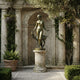 Life-Size Classical Nude Goddess with Greyhound Bronze Sculpture by Giant Sculptures on a fluted stone column in a columned garden niche with wisteria.
