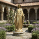 Life-Size Classical Virgin Mary Bronze Statue, 250cm, gold-toned finish with arms outstretched, displayed on a stone base in a garden cloister courtyard.