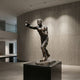 Life-Size Contemporary Boxer Bronze Sculpture by Giant Sculptures, 220cm dark brown patina figure mid-punch on a black plinth in a curved concrete gallery.