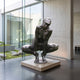 Life-Size Contemporary Crouching Female Figure Bronze Sculpture by Giant Sculptures, dark patina nude in deep crouch with arched torso, displayed on a stone plinth.