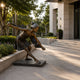 Life-Size Contemporary Dancing Girl Bronze Sculpture, 160cm, on a stone base outdoors near steps and greenery, arms spread in a dynamic dance pose.