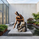 Giant Sculptures Life-Size Contemporary Seated Female Figure Bronze Sculpture 140cm with warm brown patina, displayed on a concrete plinth in a courtyard beside a reflecting pond.