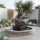 Life-Size Contemporary Seated Nude Female Figure Bronze Sculpture by Giant Sculptures on a granite boulder in a round fountain pool with succulents.