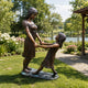 Life-Size Contemporary Two Girls Bronze Sculpture, 170cm, cast bronze figures holding hands in a garden setting on a stone base.
